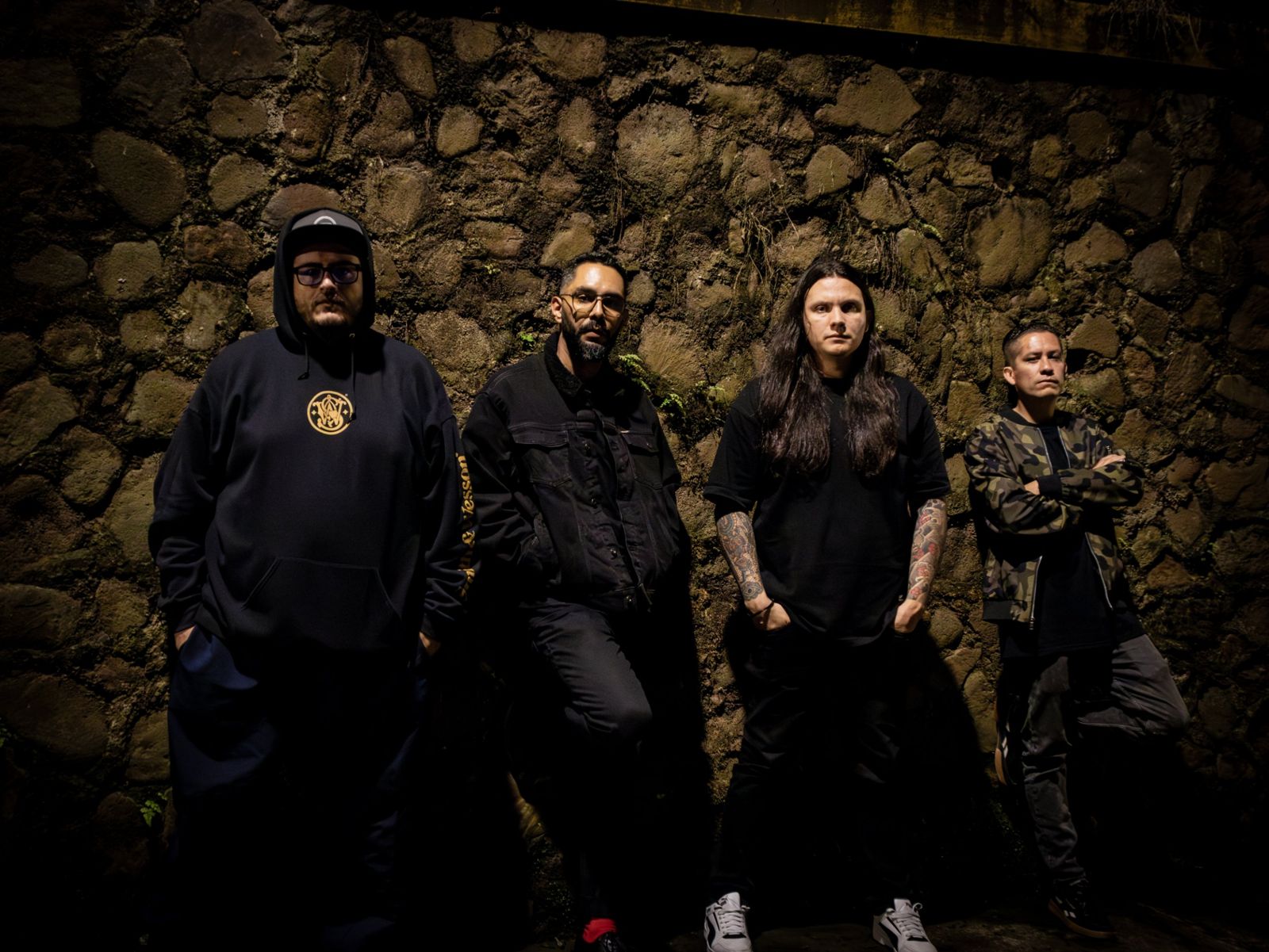 La banda de noche contra un muro de piedra